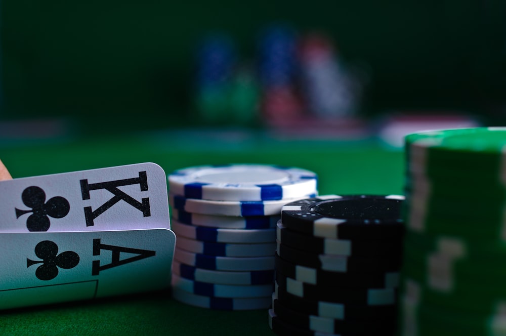 Kartu dan chip poker tersusun di atas meja felt hijau